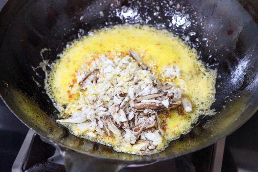 Add the Meat Add the picked white crab meat to the pot. Use your spatula to gently break up any large clumps, ensuring the meat is coated in the golden fat. Continue to simmer on low heat for another 2 to 3 minutes.