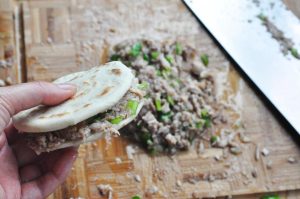 Stuff: Slice the warm buns horizontally (like a burger bun), but not all the way through—leave a "hinge" at the back. Stuff generously with the meat mixture.