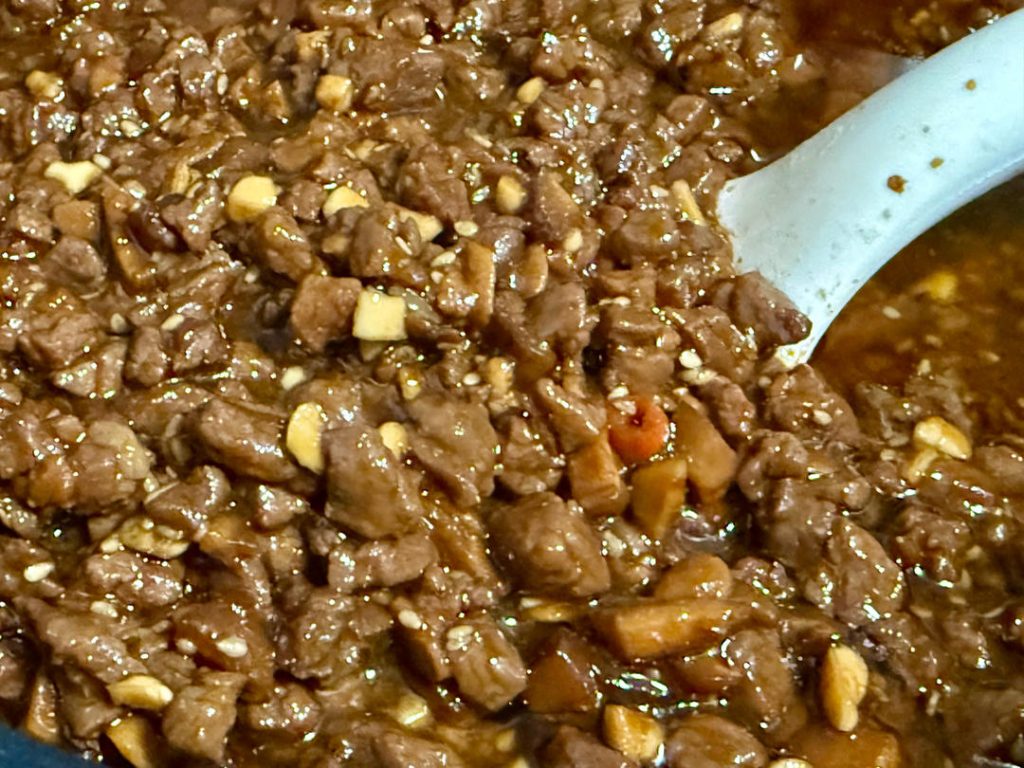 Let the sauce cool completely in the pot before transferring it to sterilized glass jars. The oil should cover the meat—this acts as a seal.