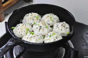 Finish: Once the water evaporates, sprinkle with chopped scallions and sesame seeds. Turn off the heat and let it sit covered for another 2 minutes (this prevents the buns from collapsing).
