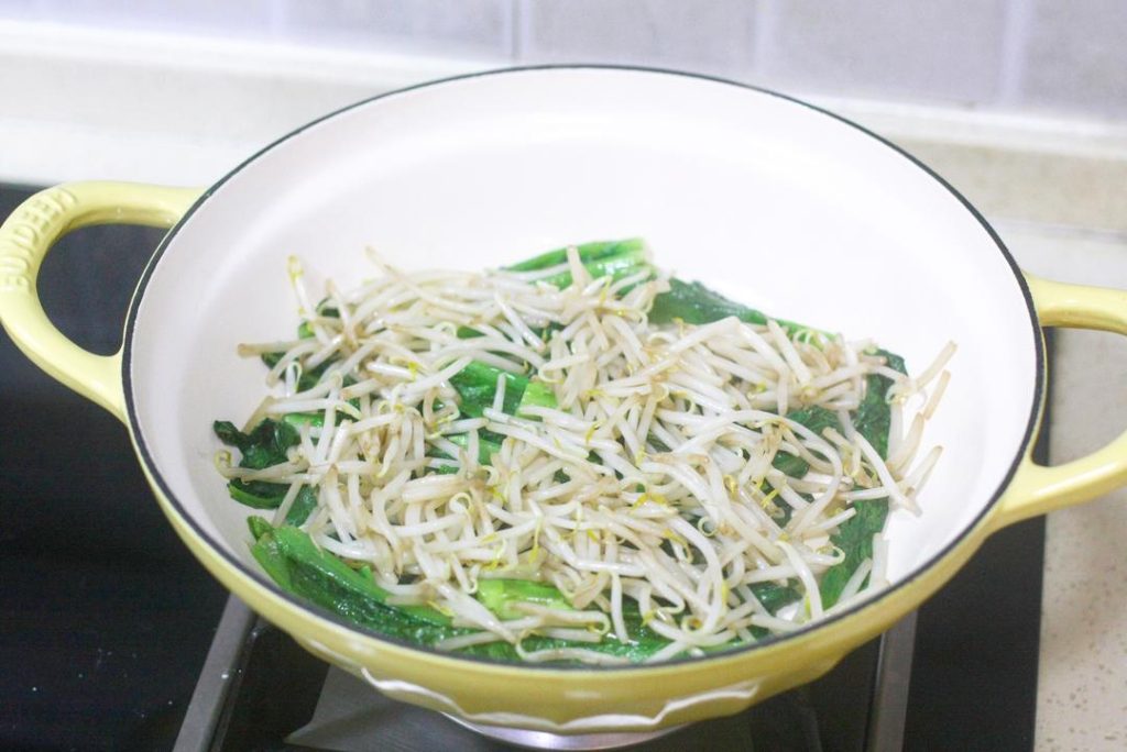 Stir-fry the Vegetables Heat a little oil in the wok. Stir-fry the leafy greens and bean sprouts until just wilted (断生 - duan sheng). Do not overcook; they should remain crunchy. Transfer them to the bottom of your serving bowl.