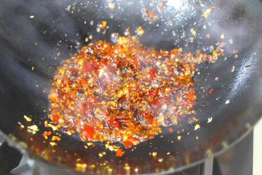 Create the Soup Base Add oil to the wok over medium heat. Add the minced pickled chilies, ginger, and the 2/3 portion of minced garlic. Stir-fry until fragrant. Add the tablespoon of Doubanjiang and stir-fry until the oil turns red (this releases the pigment and flavor). Pour in water (about 2-3 cups, enough to submerge meat). Season with 2 tsp light soy sauce, sugar, white pepper, and chicken essence. Bring to a boil. Add a little cornstarch slurry to slightly thicken the broth.
