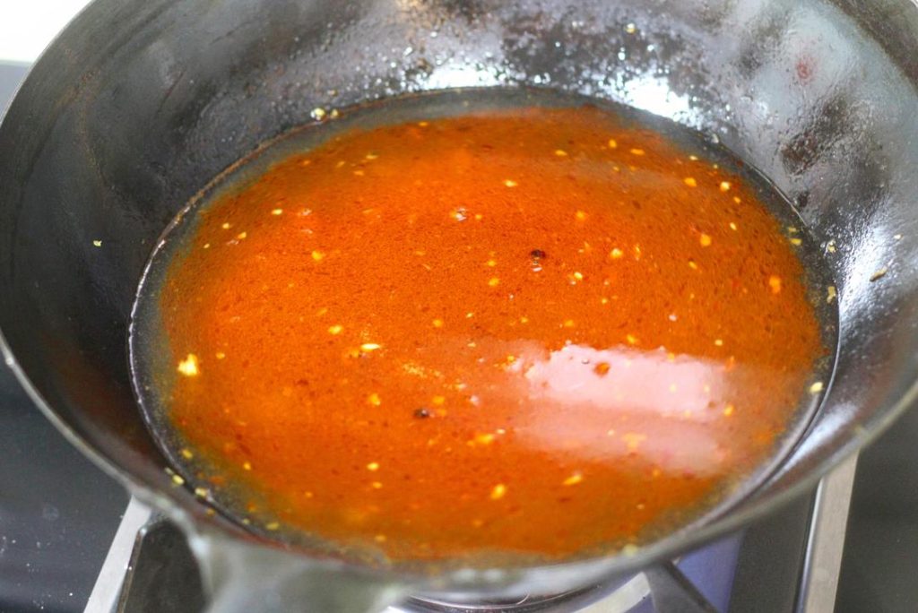 Create the Soup Base Add oil to the wok over medium heat. Add the minced pickled chilies, ginger, and the 2/3 portion of minced garlic. Stir-fry until fragrant. Add the tablespoon of Doubanjiang and stir-fry until the oil turns red (this releases the pigment and flavor). Pour in water (about 2-3 cups, enough to submerge meat). Season with 2 tsp light soy sauce, sugar, white pepper, and chicken essence. Bring to a boil. Add a little cornstarch slurry to slightly thicken the broth.
