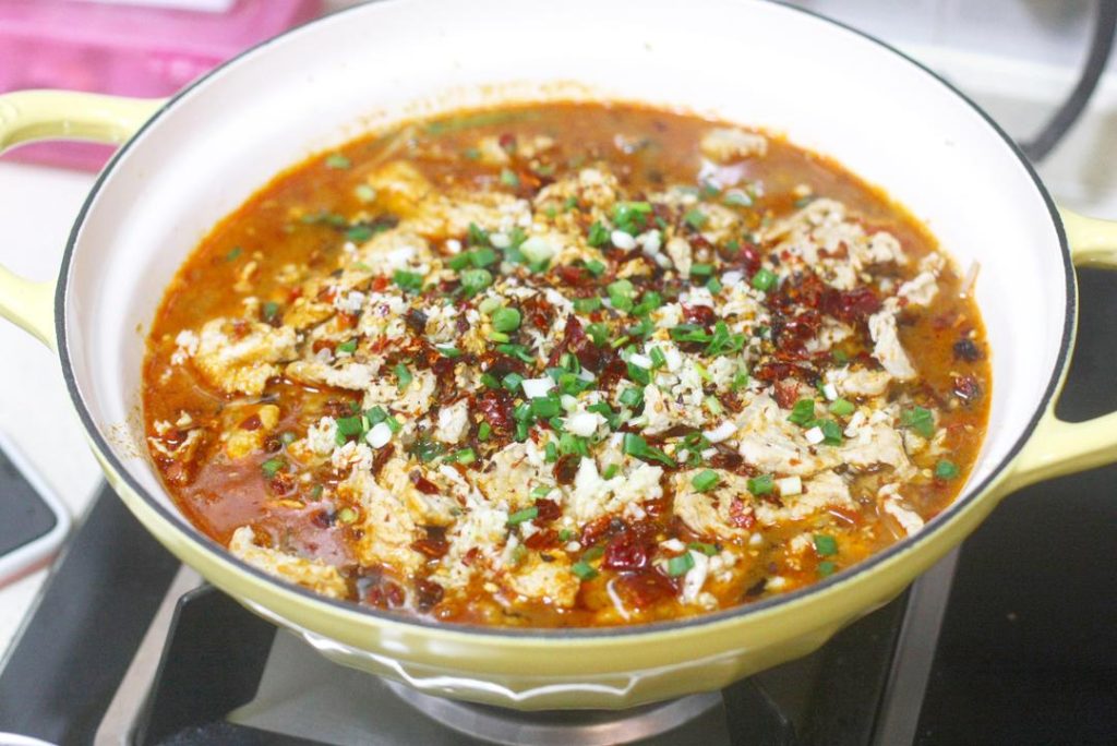 Assemble and The Final Splash Pour the meat and broth over the vegetables in the serving bowl. Now, pile the reserved minced garlic, the Knife-Edge Chilies you made earlier, and the chopped green onions directly on top of the meat mound.