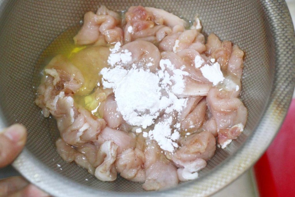 Add salt, white pepper, 1 tsp light soy sauce, and Shaoxing wine. Mix well with your hand until the liquid is absorbed. Add the egg white and potato starch. Mix vigorously until the pork feels sticky. Finally, add a teaspoon of oil to coat the meat (this prevents sticking later). Cover and let rest for 20-30 minutes.