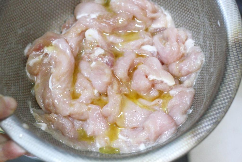 Add salt, white pepper, 1 tsp light soy sauce, and Shaoxing wine. Mix well with your hand until the liquid is absorbed. Add the egg white and potato starch. Mix vigorously until the pork feels sticky. Finally, add a teaspoon of oil to coat the meat (this prevents sticking later). Cover and let rest for 20-30 minutes.