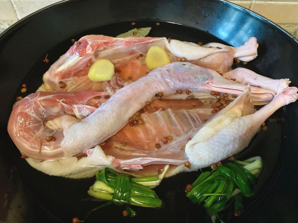 Prepare the Braise: Do not wash off the marinade! Place the duck directly into a large pot. Add enough cold water to just submerge the bird. Add the scallion knots, ginger slices, 1 gram of Sichuan peppercorns, bay leaves, 2 grams of salt, sugar, oyster sauce, and Shaoxing wine.