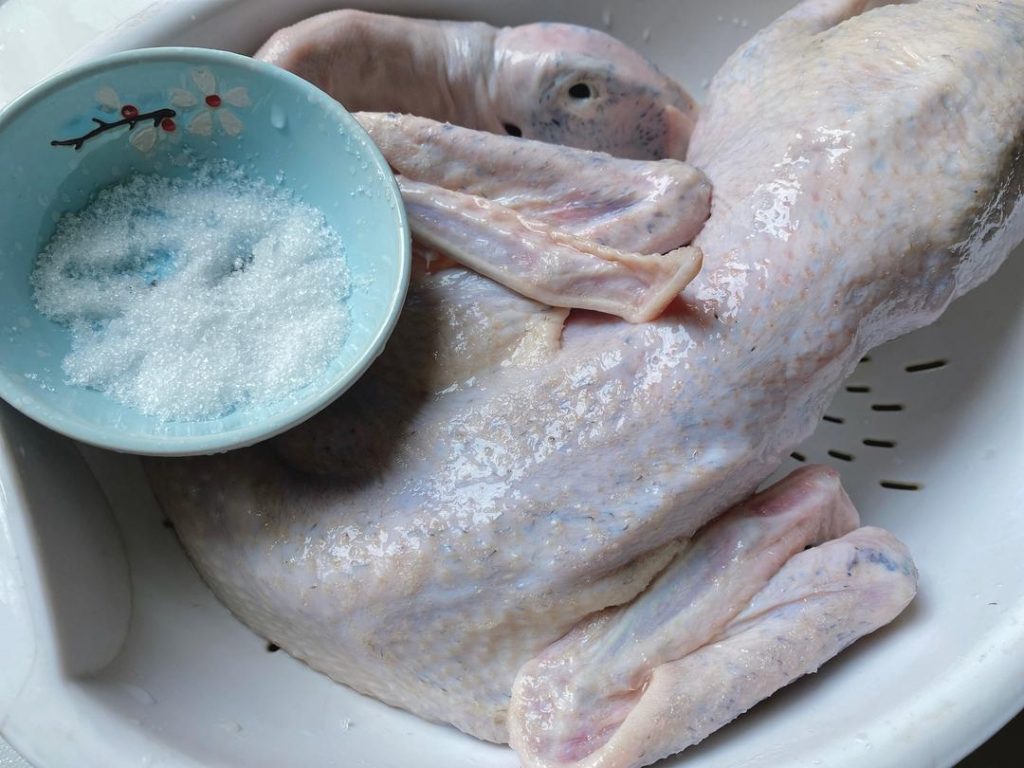 Clean the Duck: Remove any remaining pinfeathers, inner organs, and the tail. Rub the entire duck thoroughly with a handful of plain salt to clean the skin. Rinse thoroughly under cold running water to wash away blood and impurities. Pat the duck completely dry inside and out.