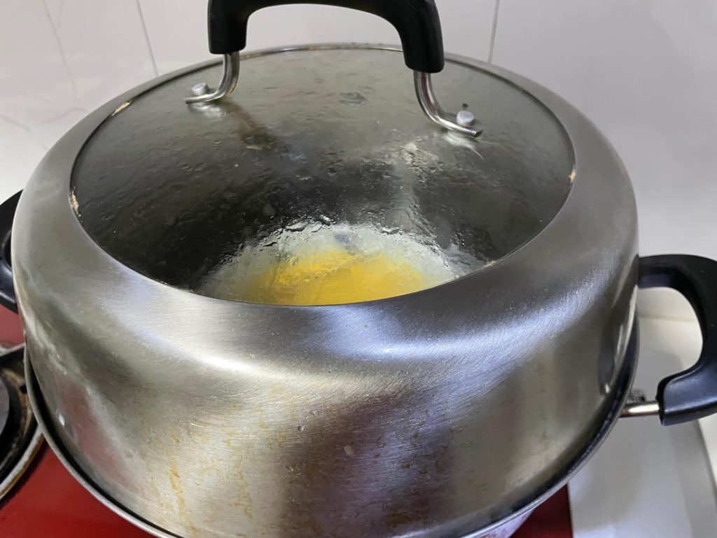 The First Steam: Carefully place the bowl onto the steamer rack. Reduce the heat to medium-high to maintain a steady, gentle simmer. Cover the pot and steam for 11 minutes.
