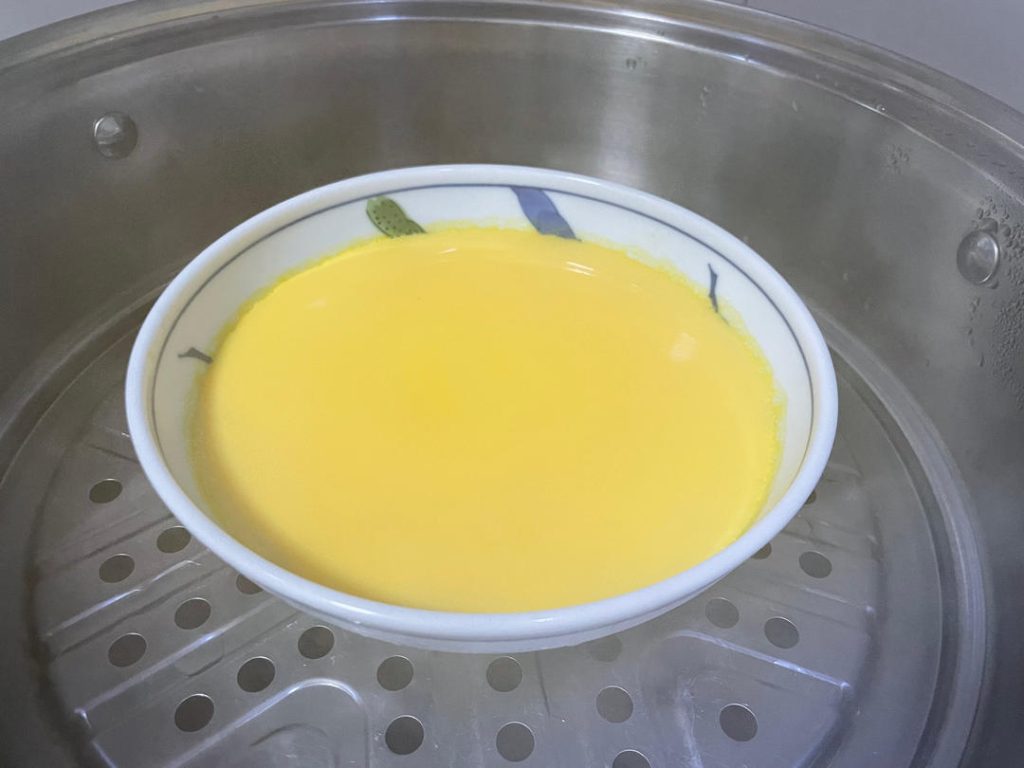 The First Steam: Carefully place the bowl onto the steamer rack. Reduce the heat to medium-high to maintain a steady, gentle simmer. Cover the pot and steam for 11 minutes.
