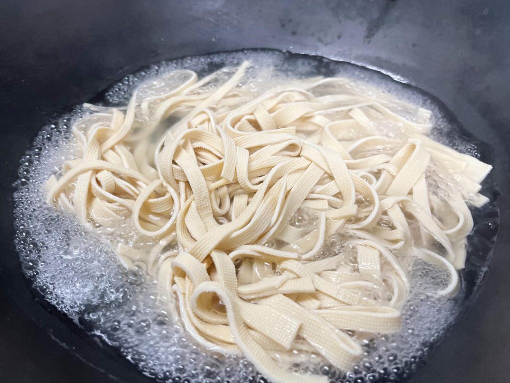 Bring a pot of water to a boil. Add the sliced tofu skin strips.