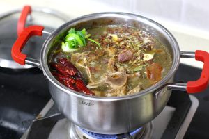 The Simmer Pour in enough hot water to just cover the lamb bones. Add your Spice Sachet (or loose spices), the scallion knot, and the dried chilies.