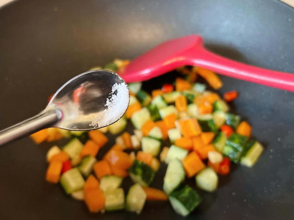 Season the Vegetables: Sprinkle in a tiny pinch of salt, followed by 1 tablespoon of oyster sauce. Toss constantly to coat the vegetables evenly.
