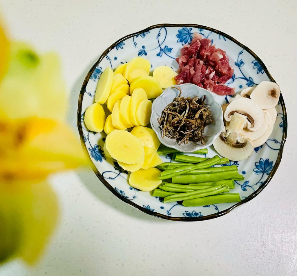Begin by organizing your workspace. Wash and trim the green beans, peeling the potatoes right before cooking to prevent oxidation. Next, slice the mushrooms and shred the pork tenderloin.