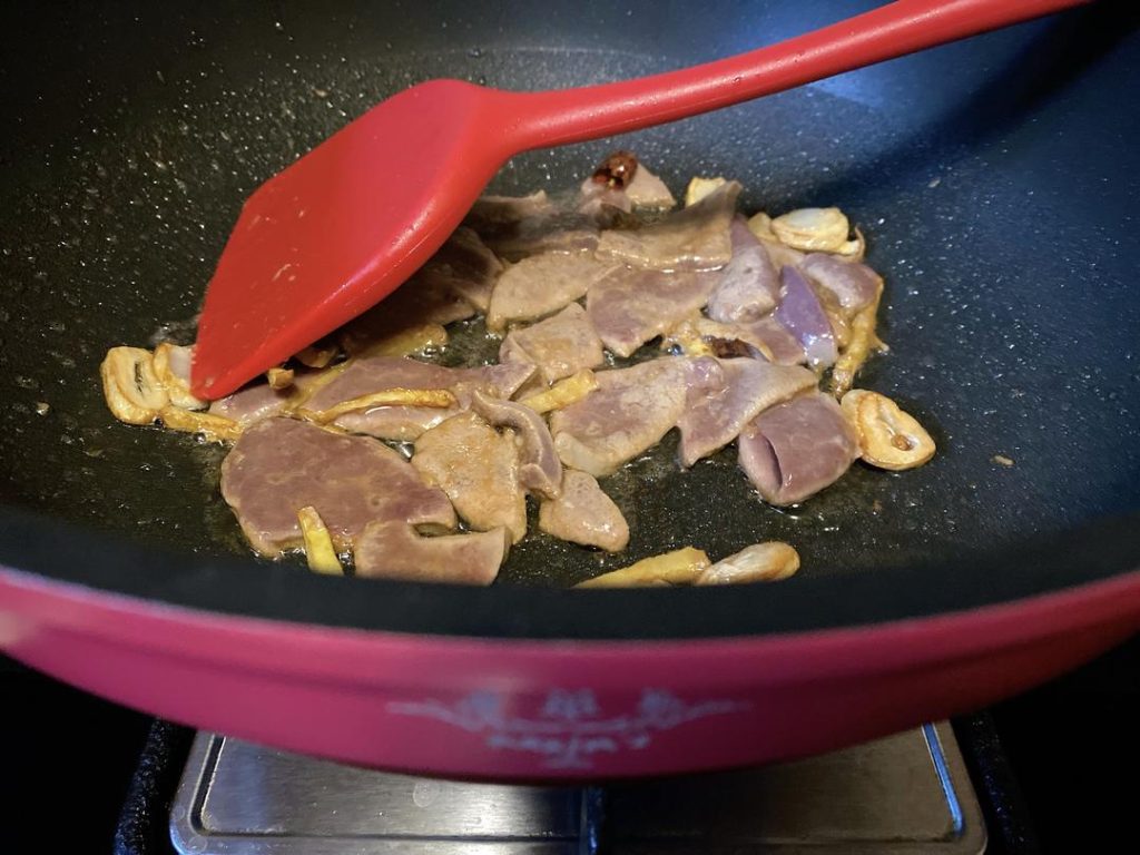Flash Fry the Liver: Add the marinated pork liver to the pan. Spread the slices out quickly so they cook evenly. Stir-fry constantly for 2 to 3 minutes.