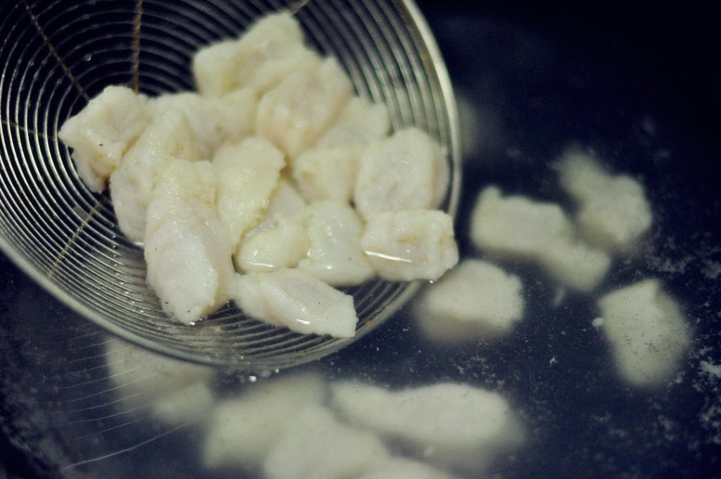 Blanch the Fish Bring a pot of water to a boil. Add the marinated fish pieces. Cook just until they turn opaque and white (about 30-45 seconds). Do not overcook. Immediately remove with a slotted spoon and set aside.
