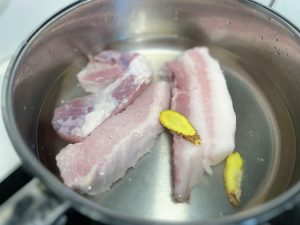 Prep the Pork Wash the fresh pork belly thoroughly. Remove the skin if preferred (this recipe suggests skinless for a cleaner bite). Place the pork in a pot of cold water—enough to submerge it completely. Add two slices of ginger.