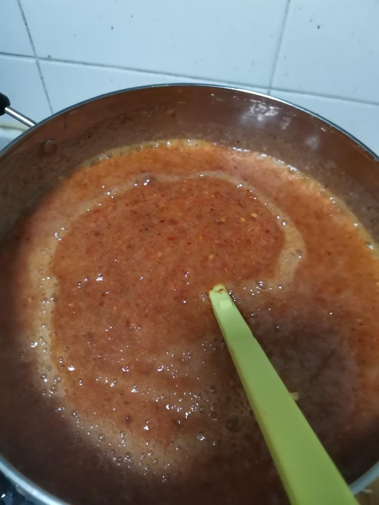 Integrate Aromatics & Spice: Pour in the blended fruit/garlic mixture and the chili powder. Use your spatula to fold everything together until the color is a uniform, vibrant red.