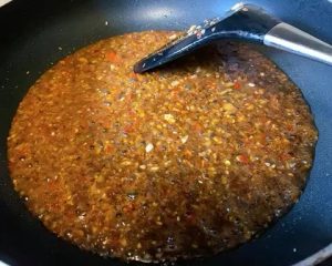 Bloom the Spices: Add the chopped Zha Cai and chili sauce to the garlic. Sauté for another 30 seconds until the red oil releases and smells aromatic.
