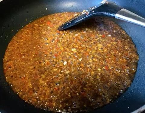 Bloom the Spices: Add the chopped Zha Cai and chili sauce to the garlic. Sauté for another 30 seconds until the red oil releases and smells aromatic.