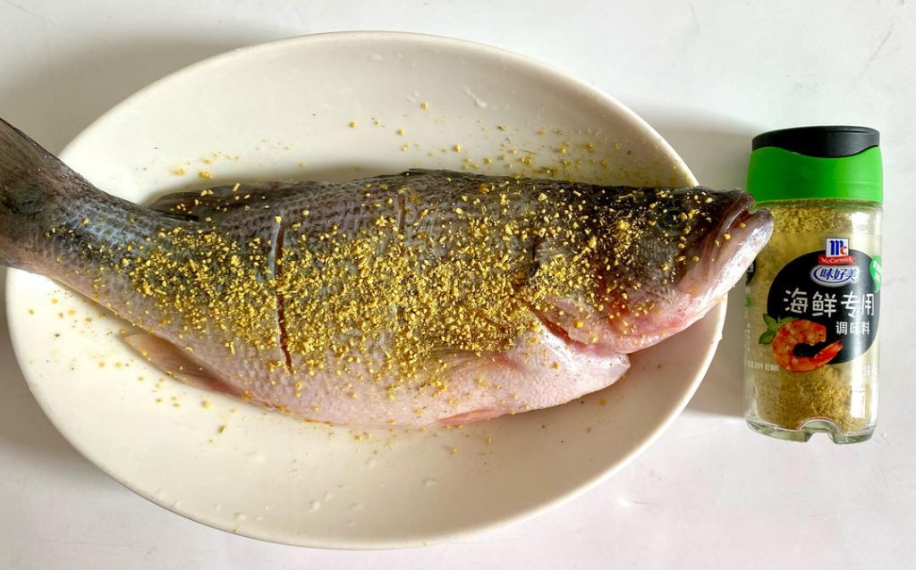 Marinate: Rub the seafood seasoning evenly all over the fish, making sure to get it inside the scored cuts and the cavity. Let it marinate for 30 minutes.