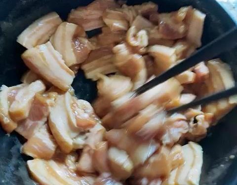 Add the thinly sliced pork to the bowl. Use a pair of chopsticks to stir the meat continuously in one direction for about 2 minutes.