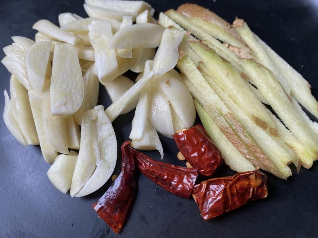 Prepare the Aromatics: Mince your ginger, garlic, and chilies so they are ready to hit the hot oil.