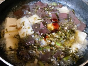 For Method 1: Heat 1 tbsp of oil in your wok over medium heat. Sauté the garlic and the white parts of the scallions (or chive stems) until fragrant. Toss in the pickled mustard greens and stir-fry for 30 seconds.