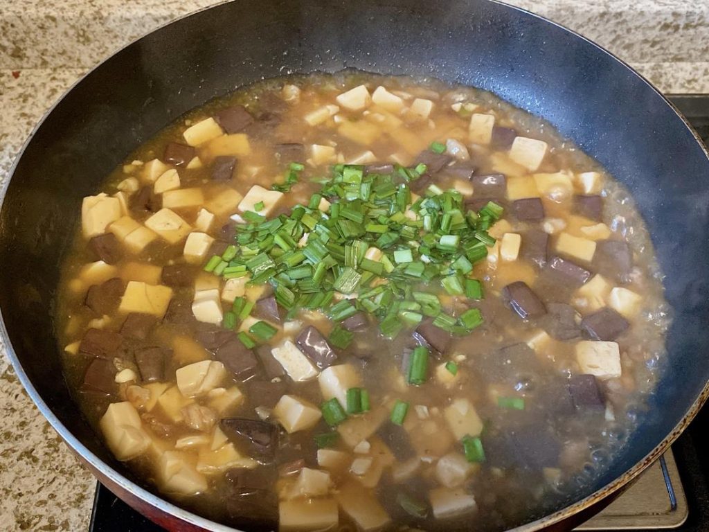 For Method 2: Give your cornstarch slurry a quick stir, then drizzle it into the simmering liquid in stages. Gently swirl the wok until the sauce thickens and clings to the tofu and blood curd (you might not need all the slurry). Fold in the scallion greens or chives, and serve immediately.