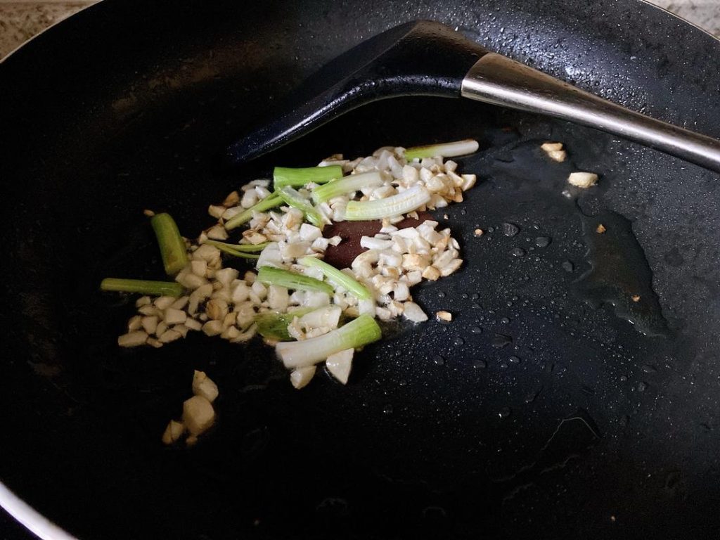 For Method 1: Heat 1 tbsp of oil in your wok over medium heat. Sauté the garlic and the white parts of the scallions (or chive stems) until fragrant. Toss in the pickled mustard greens and stir-fry for 30 seconds.