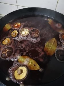 Simmer the aromatics: Add the chopped fermented black beans, dried shiitake mushrooms, red yeast rice, bay leaves, star anise, and the remaining 35g of sugar.