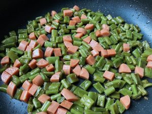 Cook until the water mostly evaporates and the beans are about 80% done (about 4 to 5 minutes). Season with a small pinch of salt and add the diced sausage, stirring for another 30 seconds.