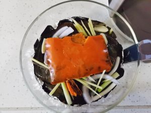 op with Flavor: Layer the remaining aromatics over the shrimp and place the chunks of spicy hot pot base right on top.