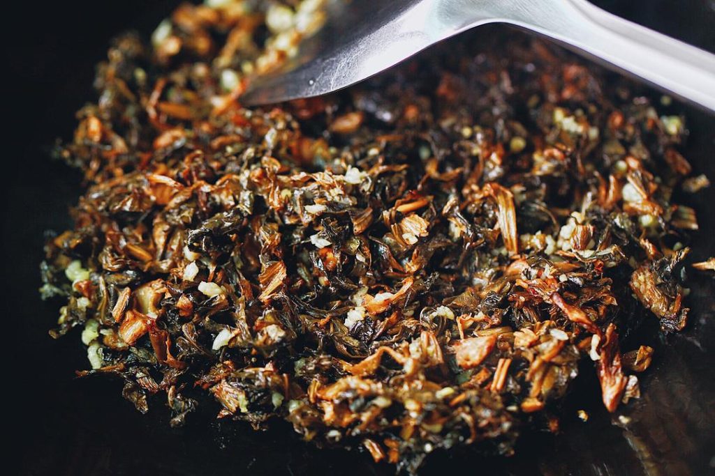 Add the chopped Mei Gan Cai and stir-fry over medium-low heat for about 2 minutes. The greens are very absorbent, but don't overdo the oil; the ribs will release more fat during the steaming process.