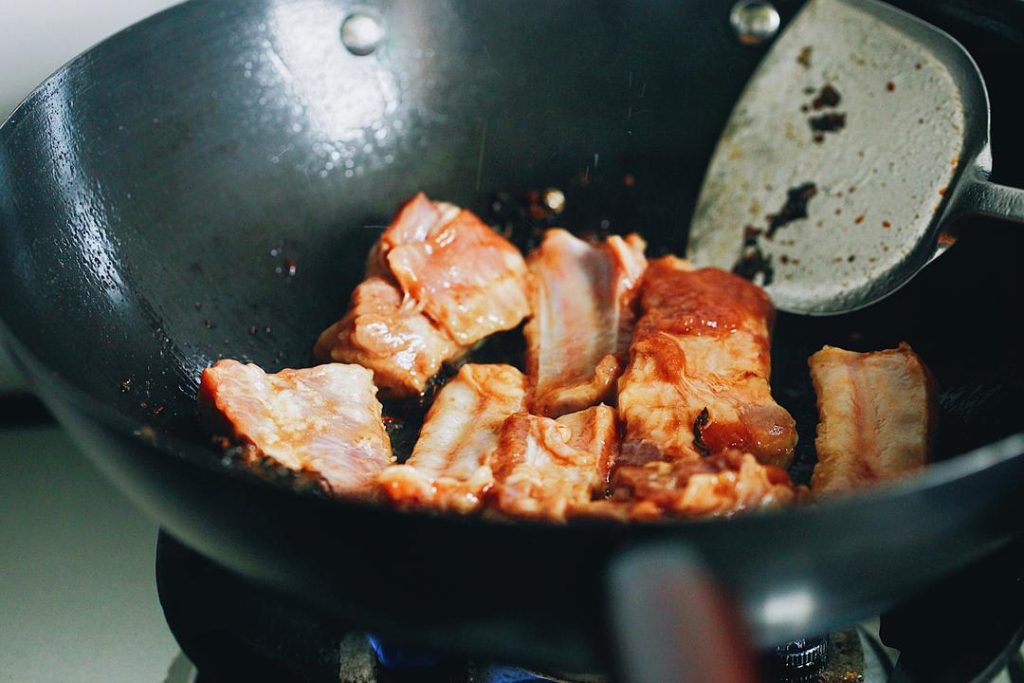 Push the greens to the side of the pan. If needed, add a tiny splash of oil and add the ribs. Sear the ribs until they just begin to change color on the surface.