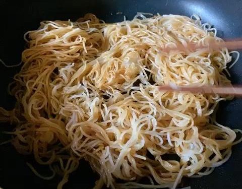 Pour the prepared seasoning sauce evenly over the noodles.