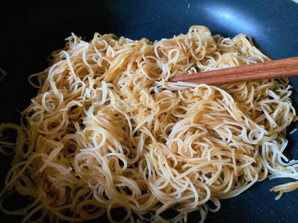 Pour the prepared seasoning sauce evenly over the noodles.