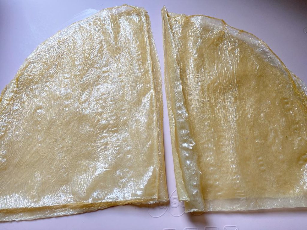 Wrap the Rolls: Cut the 2 large tofu skin sheets in half to create 4 semi-circles.