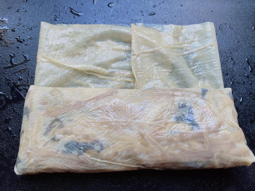 Wrap the Rolls: Cut the 2 large tofu skin sheets in half to create 4 semi-circles.