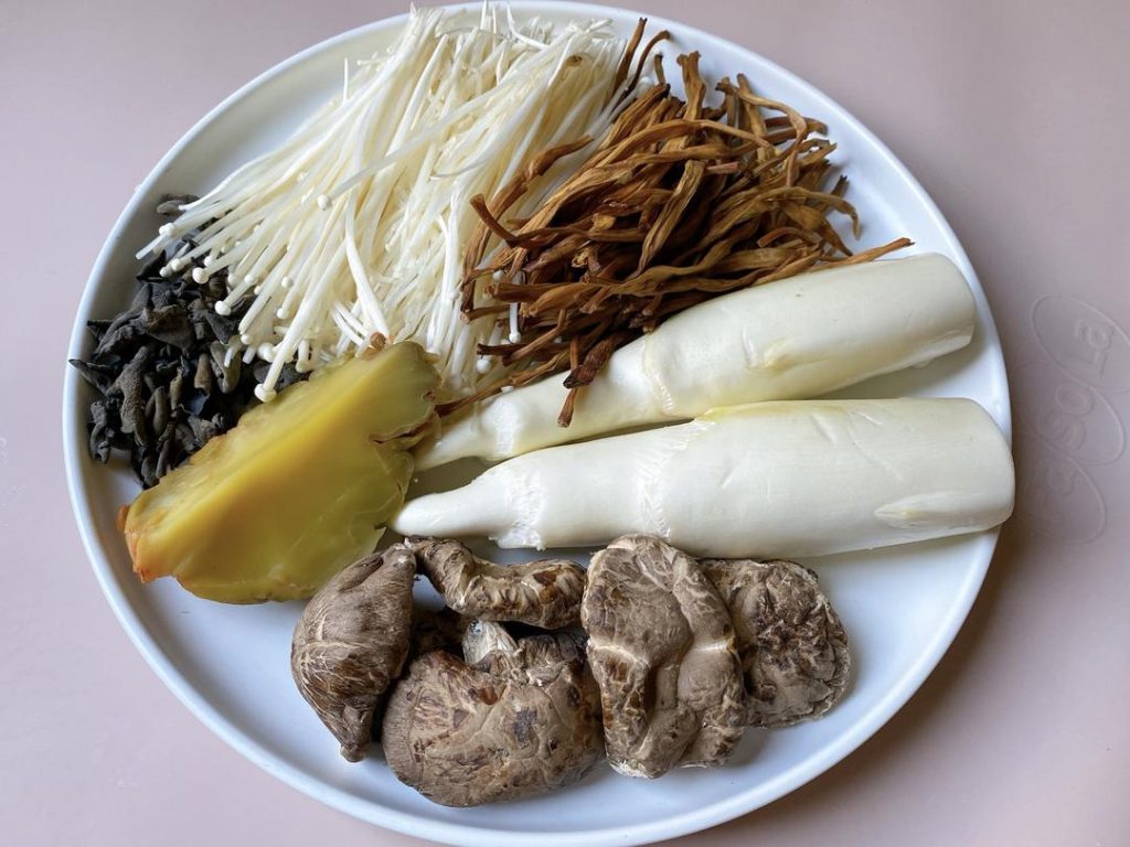 Rehydrate: Soak the dried wood ear mushrooms, dried shiitake mushrooms, and dried lily flowers in warm water for about 30 minutes until fully softened.