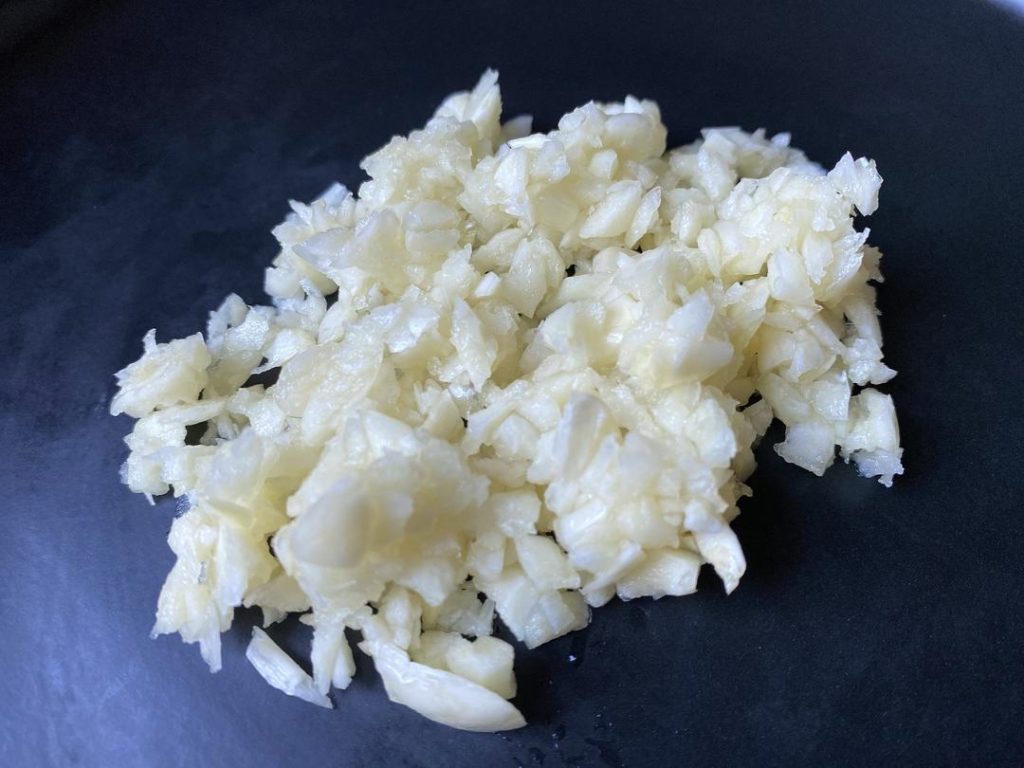 Sauté the Filling: Heat 1 tablespoon of oil in a wok over medium-high heat. Add the minced garlic and sauté until fragrant (about 30 seconds). Add the drained vegetables and stir-fry.