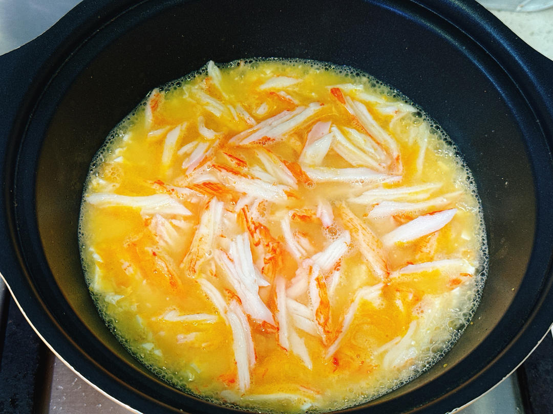 Adding crab sticks and boiling water to the egg base