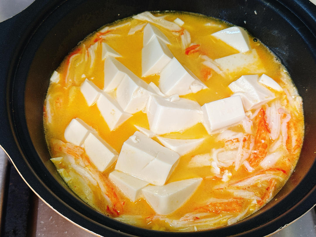 Gently simmering silken tofu cubes in the broth