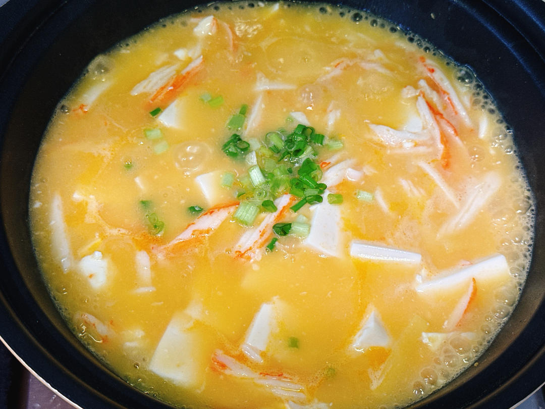Adding starch slurry and scallions then folding gently