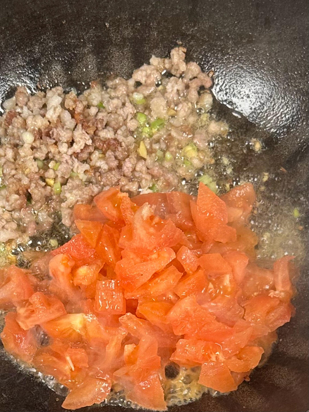 Adding peeled tomatoes to the wok until soft and juicy