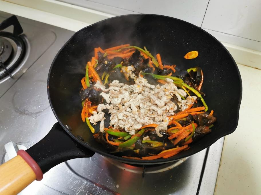 Pouring the yuxiang sauce over the stir-fried vegetables