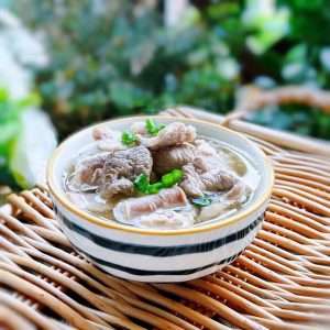 A finished bowl of ba dao tang, ready to eat with the dipping sauce — the classic Hakka morning.