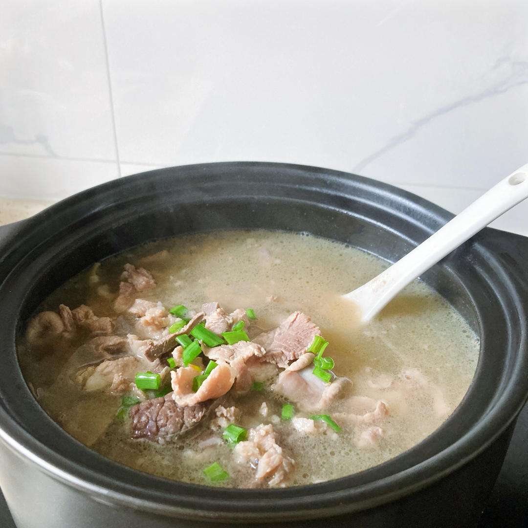 Ladle the seasoned eight-cut soup into bowls and scatter chopped scallions on top.