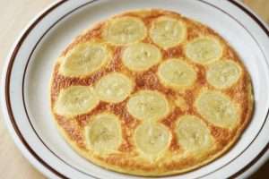 Slice the finished banana egg pancake like a cake and serve warm.