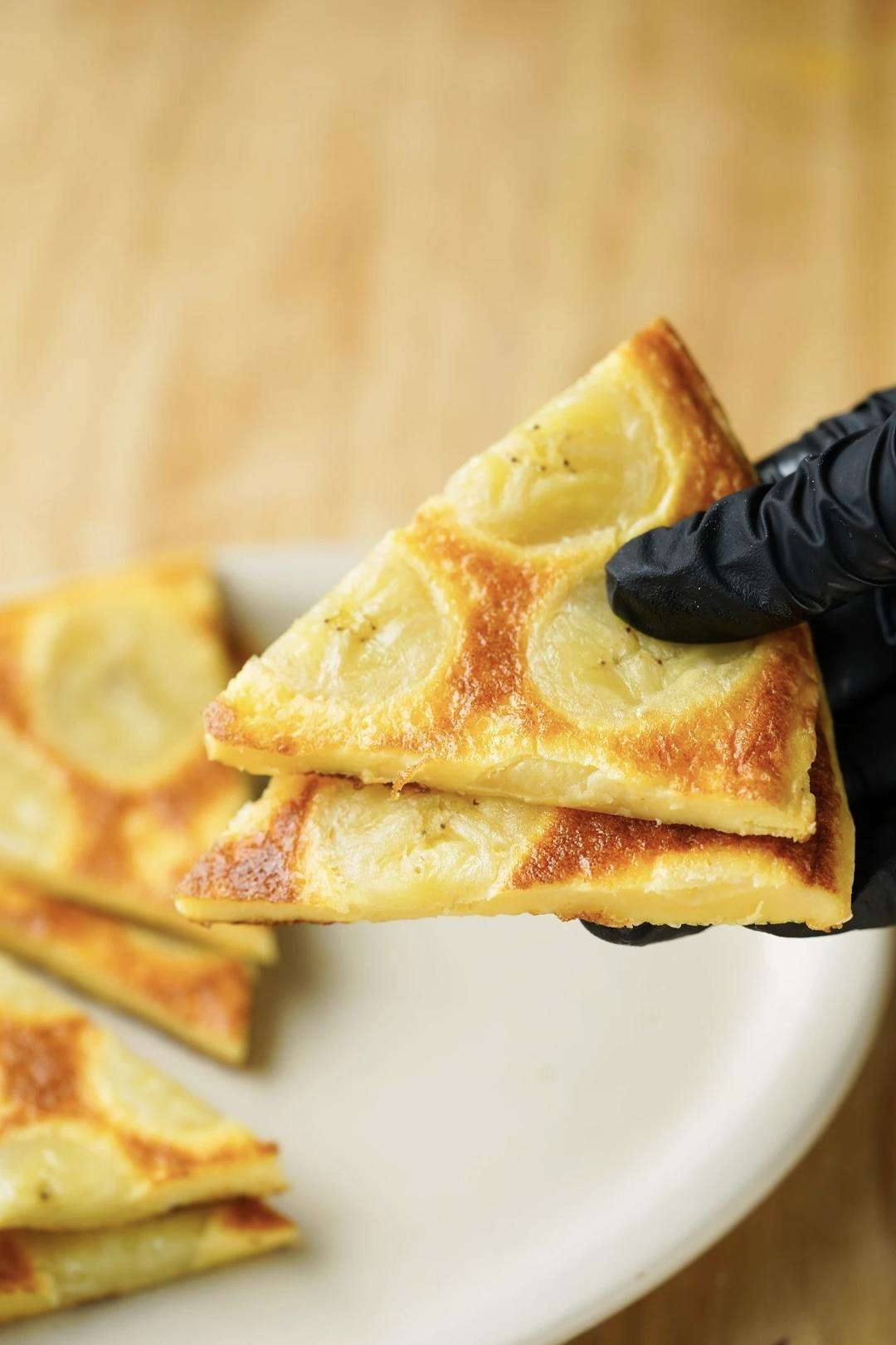 A thick golden banana egg pancake, soft and cake-like, ready to slice